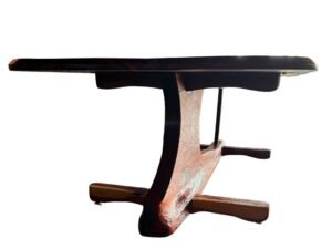 Continuum Table by Sculptera in cedar, end view: dark tabletop edge above the curved carved pedestal and cross-shaped feet